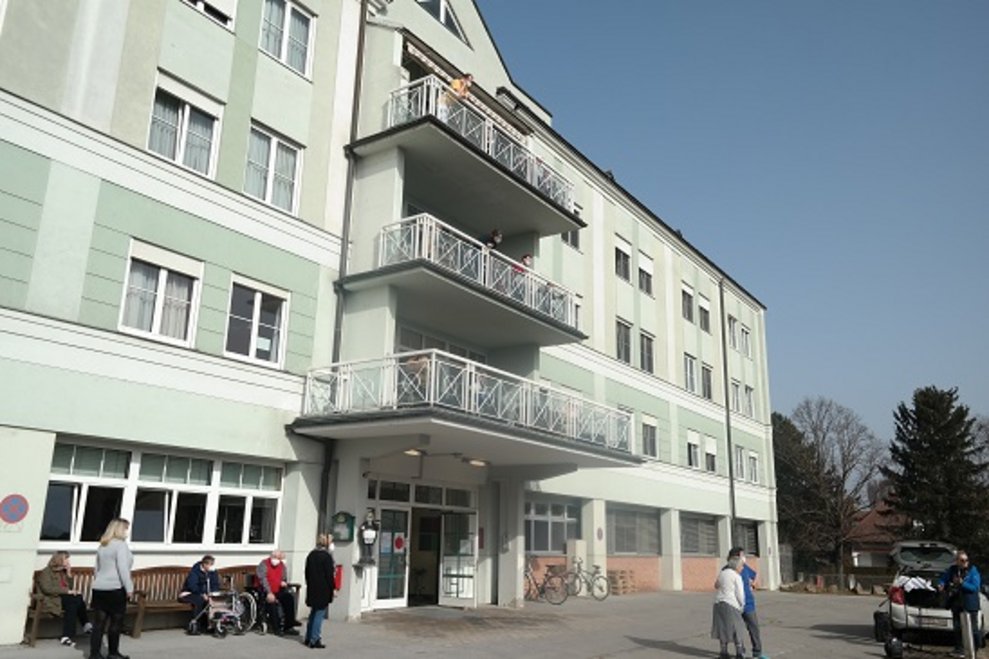 BewohnerInnen sitzen draußen.