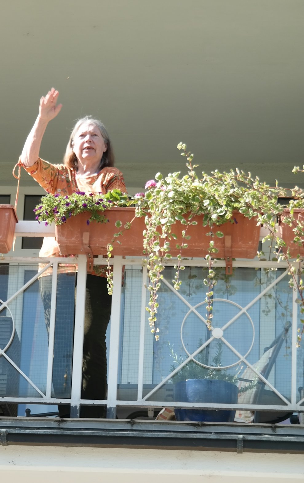 Eine Bewohnerin steht am Balkon.