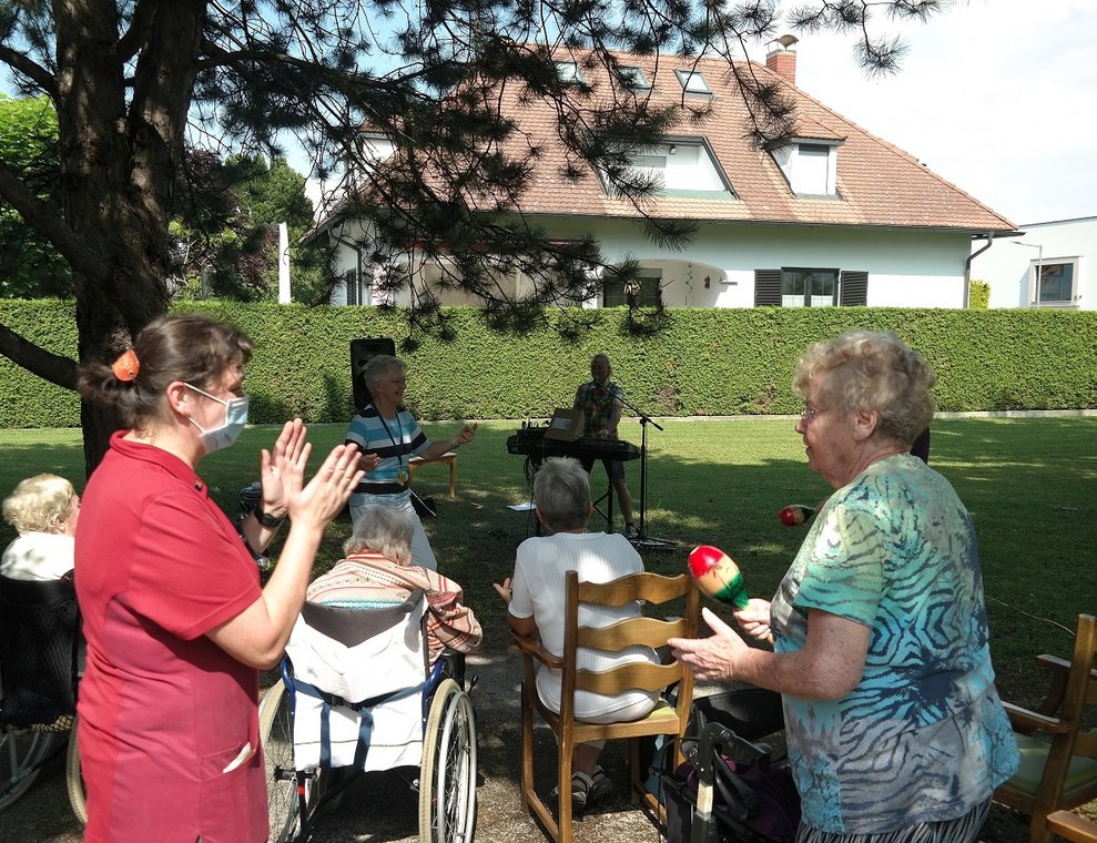 BewohnerInnen und eine Betreuerin sind draußen.