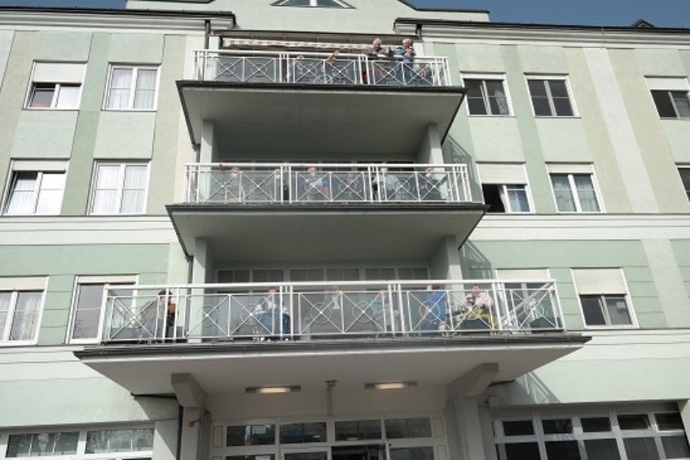 BewohnerInnen sind auf dem Balkon.