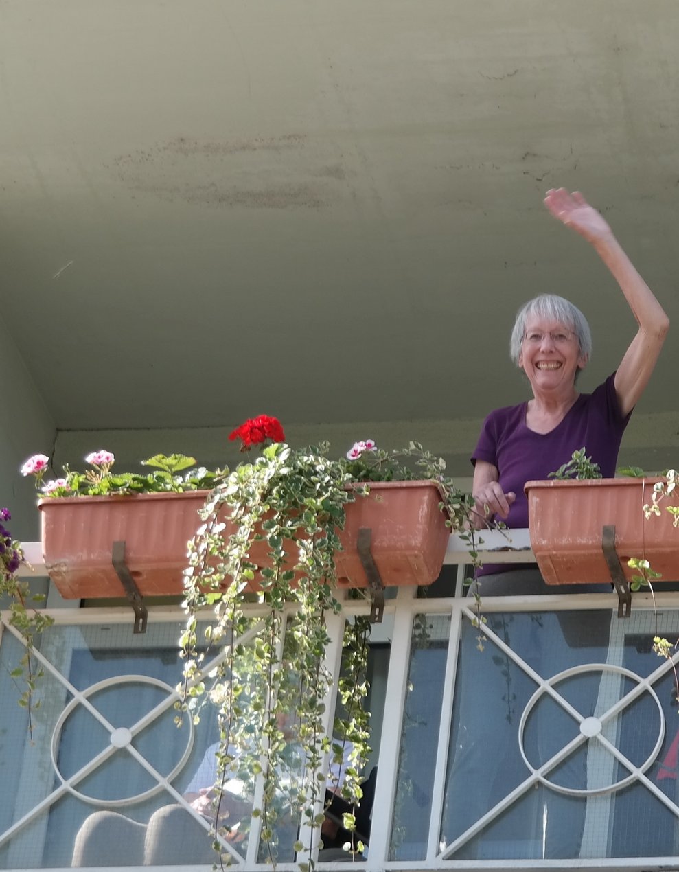 Eine Bewohnerin steht am Balkon.
