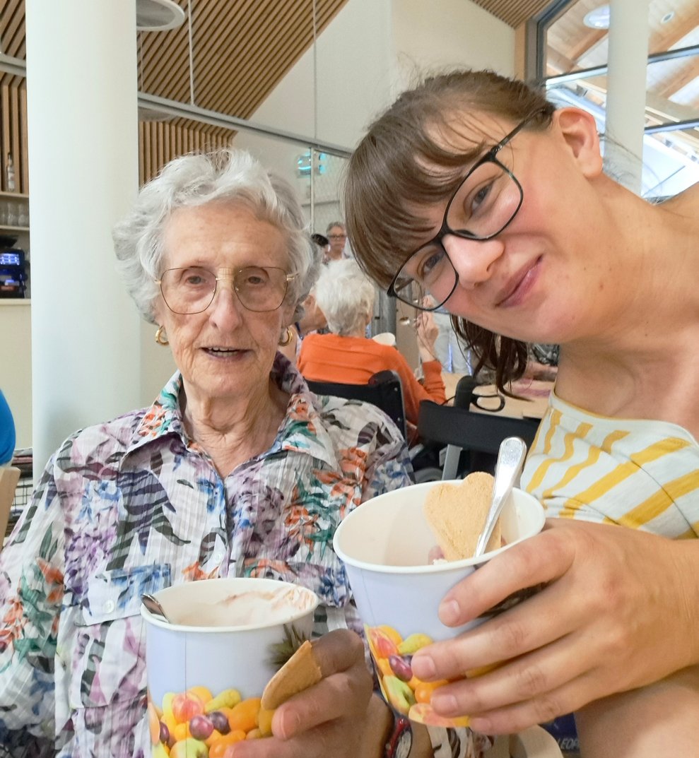 Bewohnerin Christine Gruber und Managerin Ehrenamt Julia Zeller stoßen auf das herrliche Eis an